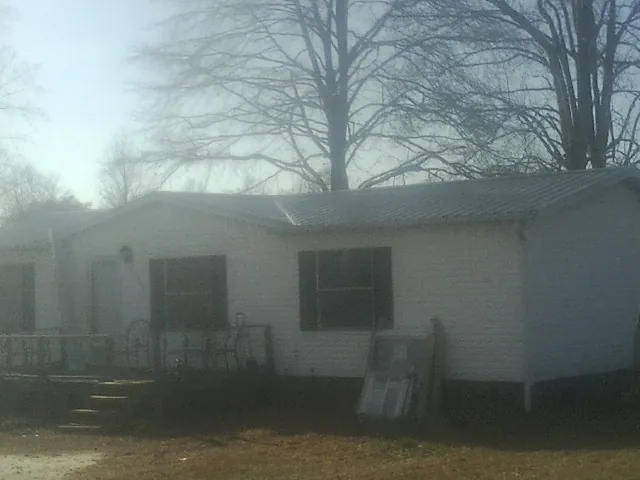 New metal roof on a white painted brick home on a foggy morning in Hiram